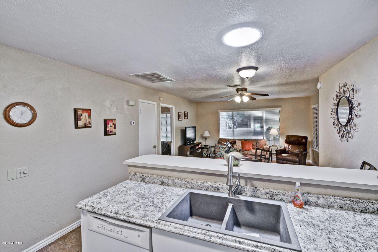 14300 West Bell Road, Unit 162 Surprise, AZ 85374 - Photo 5 of 23 a kitchen with granite countertop a sink and a stove