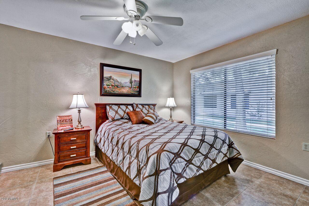 14300 West Bell Road, Unit 162 Surprise, AZ 85374 - Photo 7 of 23 a bedroom with a bed and a painting on the wall