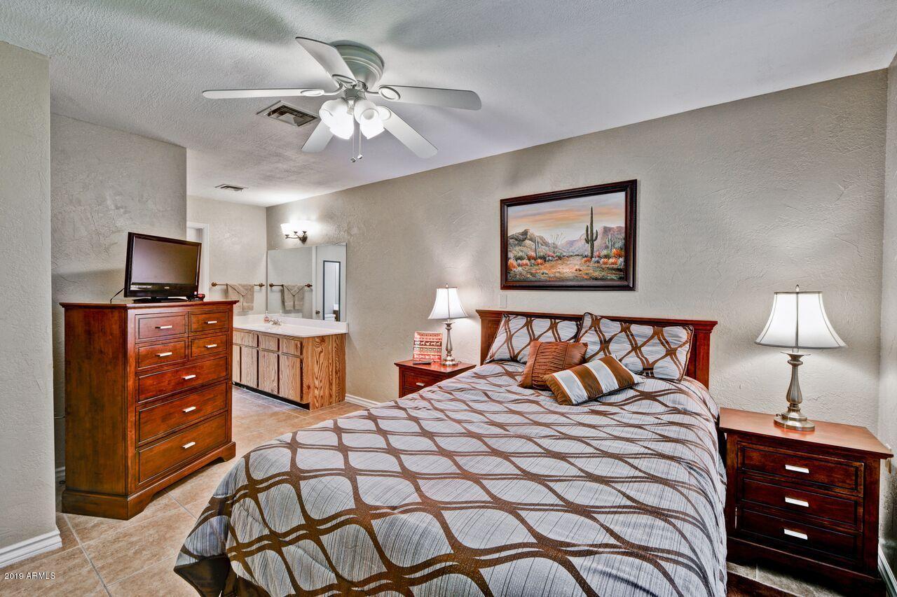 14300 West Bell Road, Unit 162 Surprise, AZ 85374 - Photo 8 of 23 a bedroom with a bed and a lamp on dresser