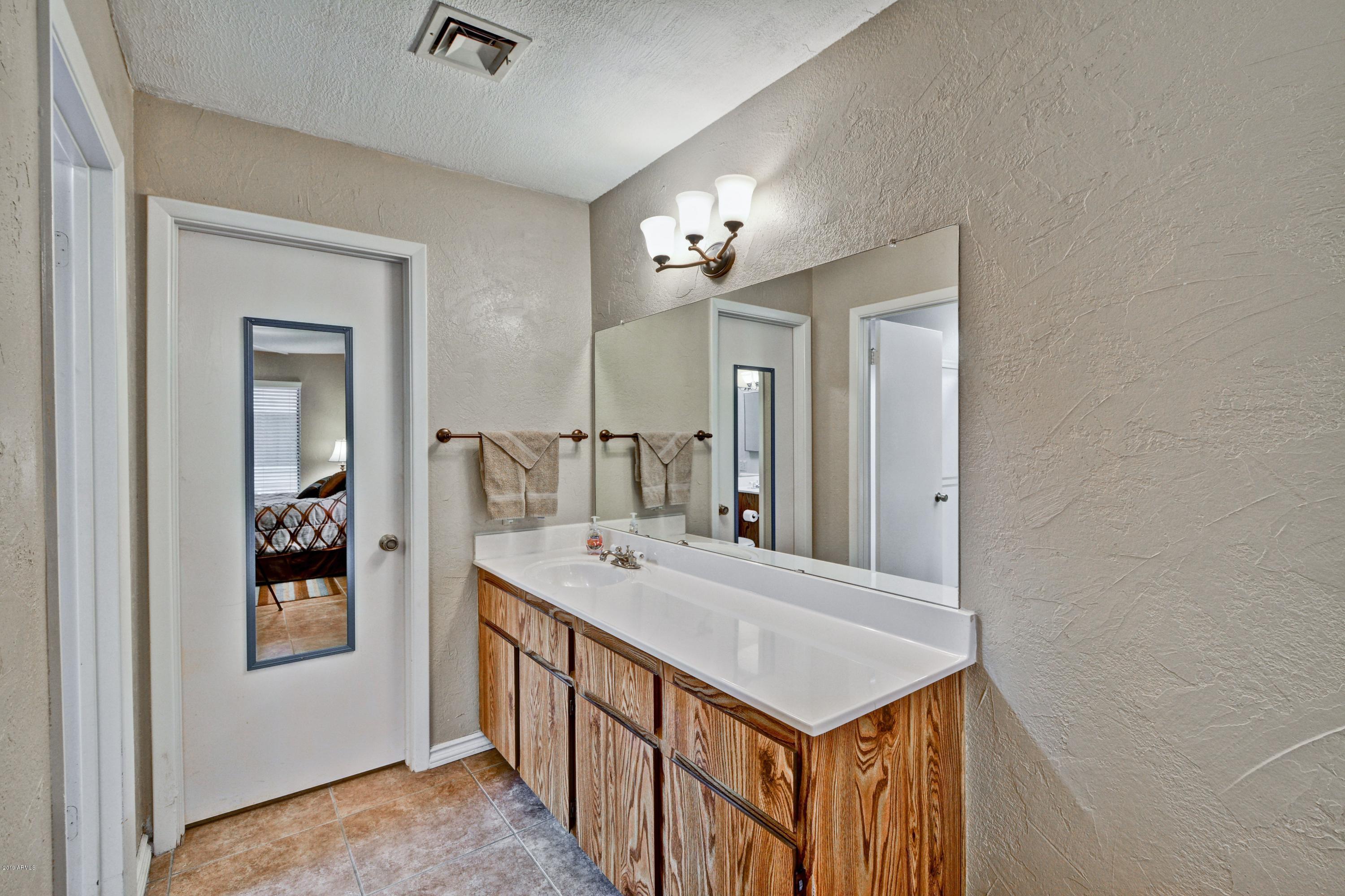 14300 West Bell Road, Unit 162 Surprise, AZ 85374 - Photo 9 of 23 a bathroom with a sink a mirror and a shower
