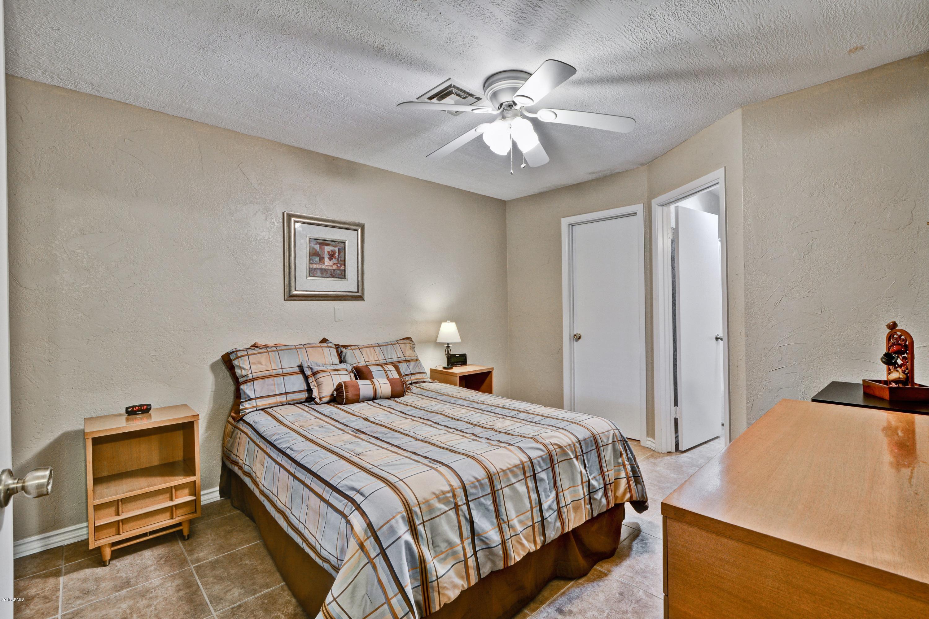 14300 West Bell Road, Unit 162 Surprise, AZ 85374 - Photo 10 of 23 a bedroom with a bed and a chandelier