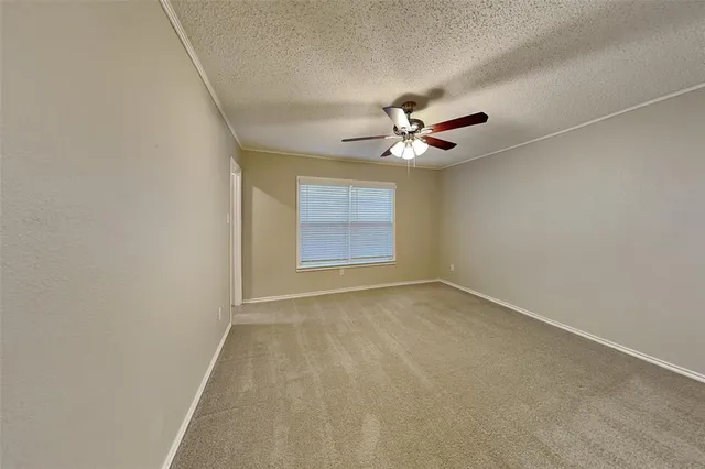 an empty room with closet and a ceiling fan