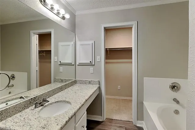 a bathroom with a granite countertop sink tub and a mirror