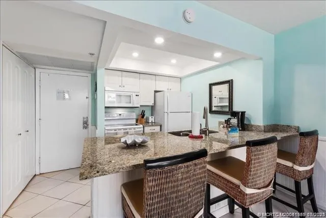 a kitchen with a table chairs refrigerator and cabinets