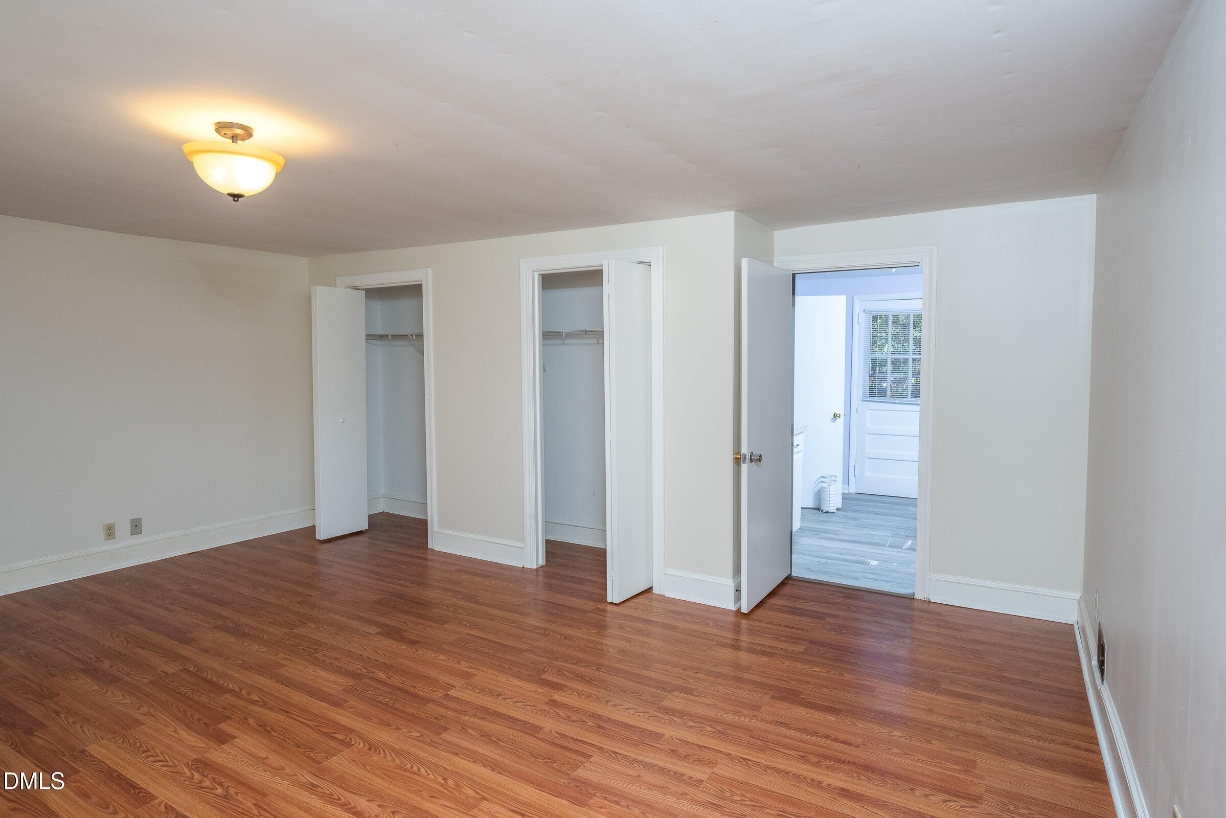 704 Pearces Road Zebulon, NC 27597 - Photo 10 of 26 an empty room with wooden floor and windows