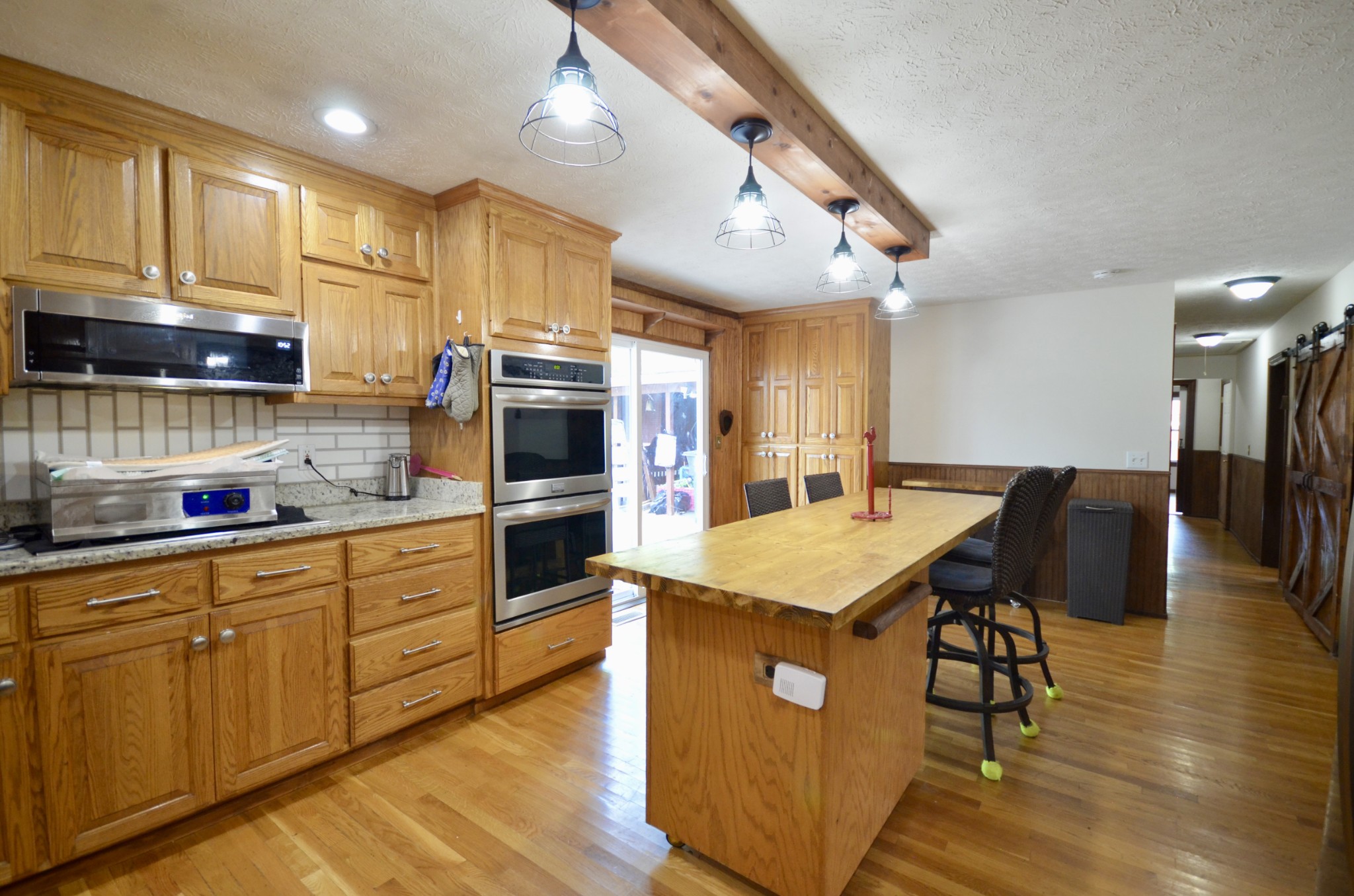 1355 Westfield Road Dickson, TN 37055 - Photo 35 of 83 a kitchen with stainless steel appliances granite countertop a kitchen island a stove a refrigerator a sink a dining table and chairs with wooden floor