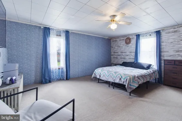 a spacious bedroom with a bed and a chandelier