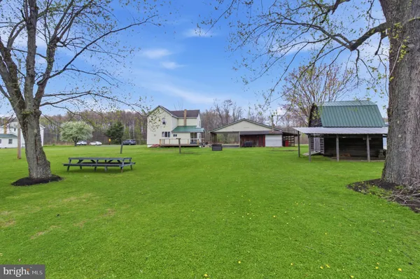 a view of a house with a big yard and large trees
