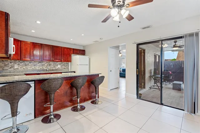 a view of kitchen with stainless steel appliances kitchen island granite countertop a refrigerator and a wooden cabinets