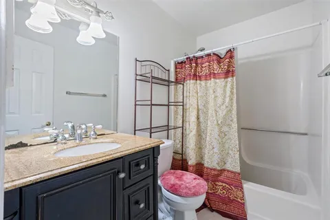 a bathroom with a sink a toilet a mirror a bathtub and shower