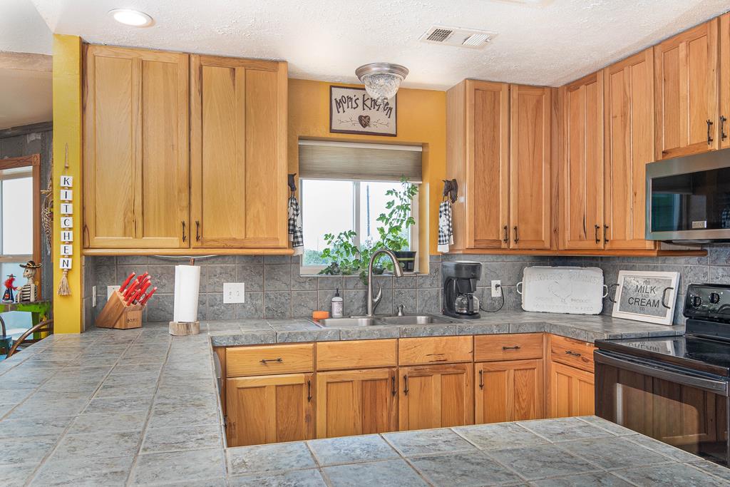 290 Japonica Road Hunt, TX 78024 - Photo 52 of 78 a kitchen with stainless steel appliances granite countertop a sink window and cabinets