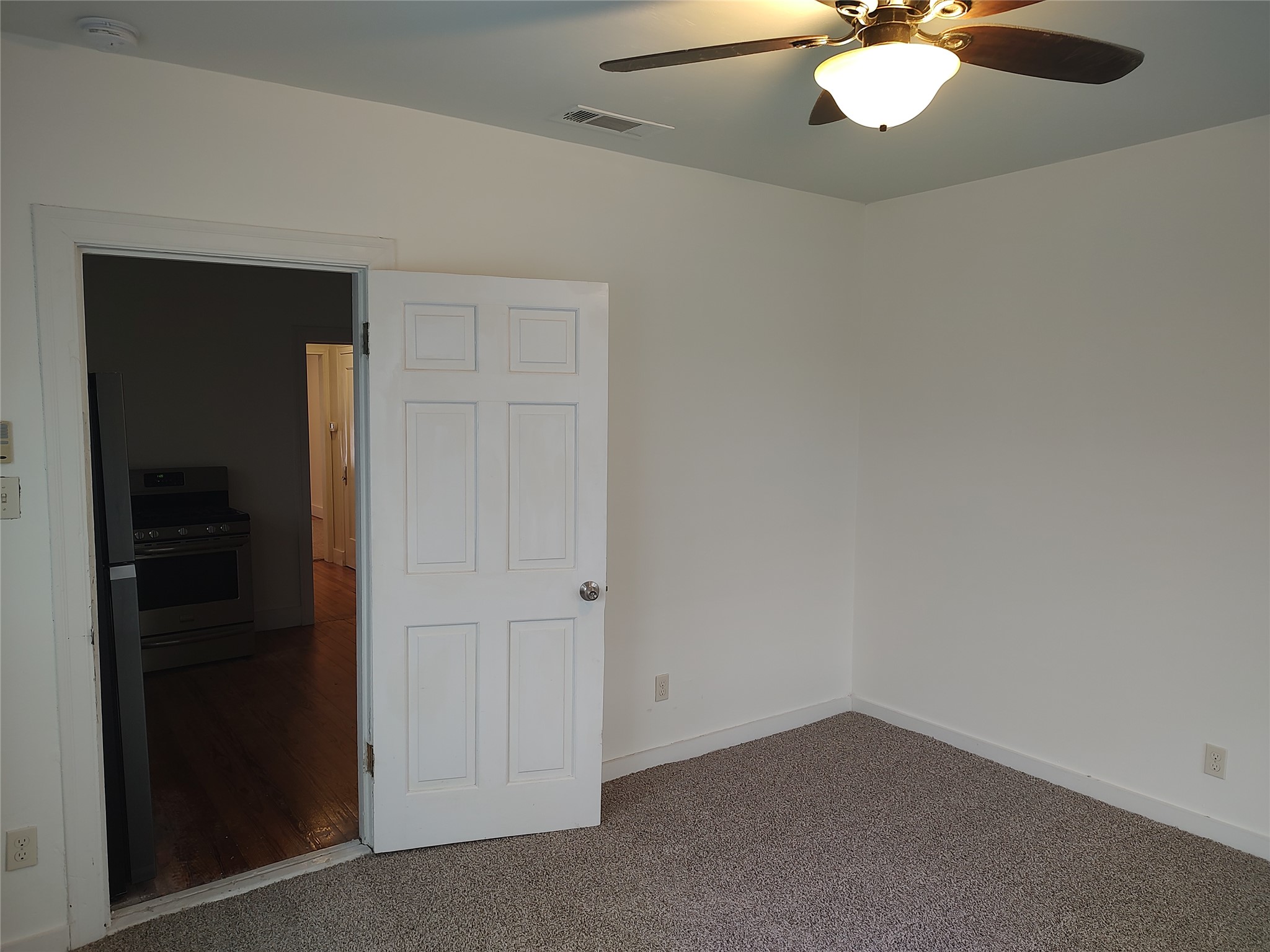 2102 Yellow Jacket Lane, Unit A Austin, TX 78741 - Photo 12 of 15 Unfurnished bedroom with carpet, freestanding refrigerator, and a ceiling fan