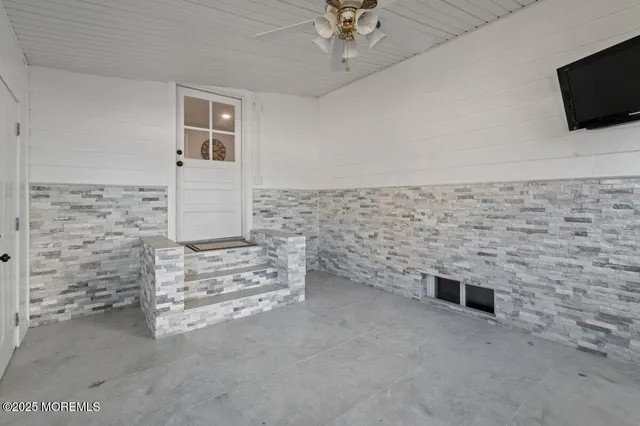 a view of empty room with fireplace and flat screen tv