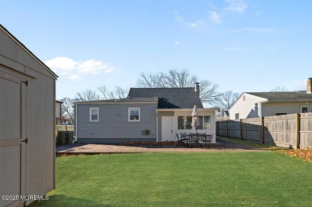 a backyard of a house with table and chairs