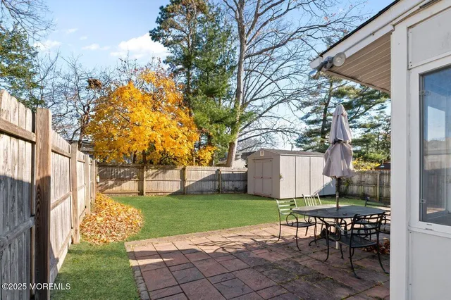 a view of a house with backyard and a tree