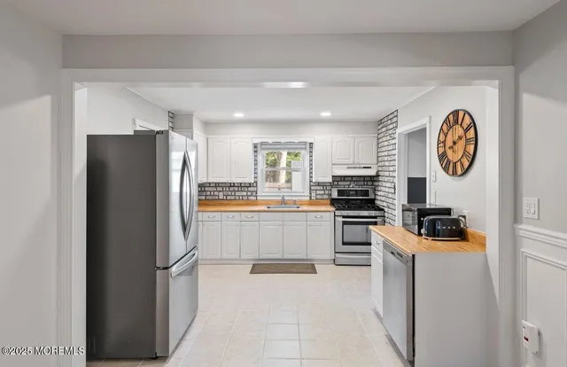 a kitchen with a refrigerator and a stove top oven