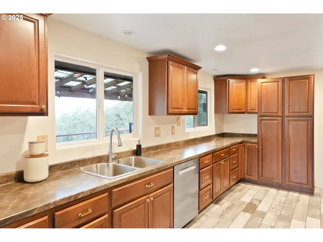 a large kitchen with stainless steel appliances kitchen island granite countertop a sink and cabinets
