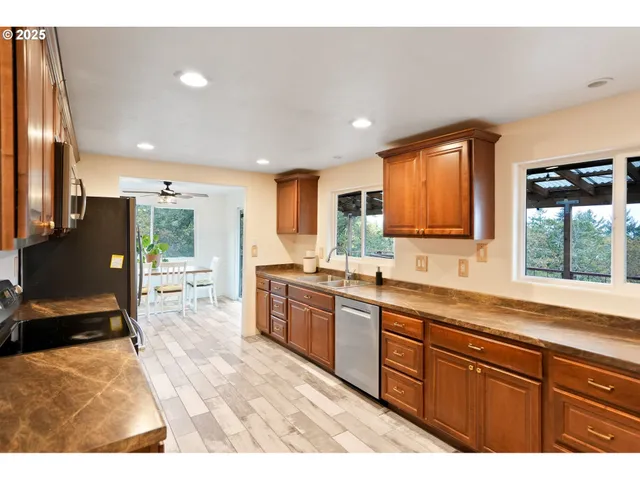 a kitchen with granite countertop a stove a sink and a refrigerator