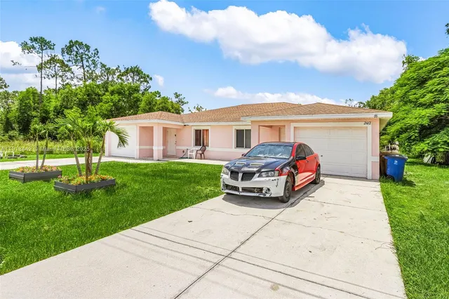 a car parked in front of a house with a garden