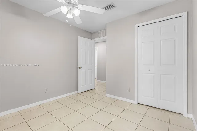 a view of an empty room and chandelier fan