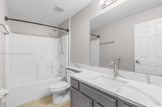 a bathroom with a sink a toilet and a large mirror