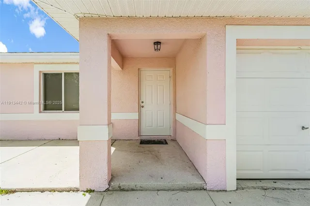a view of a hallway with wooden floor and a living room