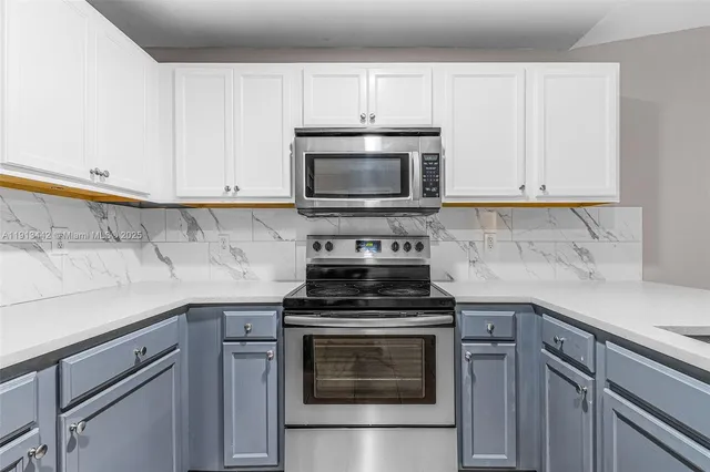 a kitchen with cabinets appliances and a sink