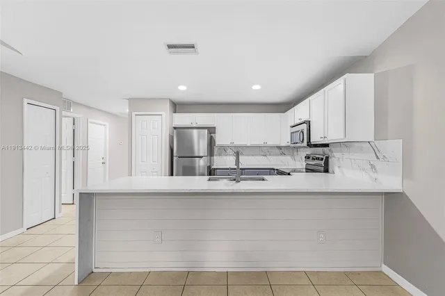 a kitchen with stainless steel appliances granite countertop a refrigerator and a stove