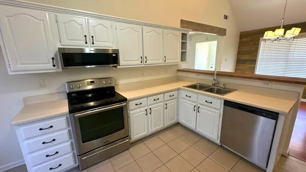 a kitchen with granite countertop white cabinets and white appliances