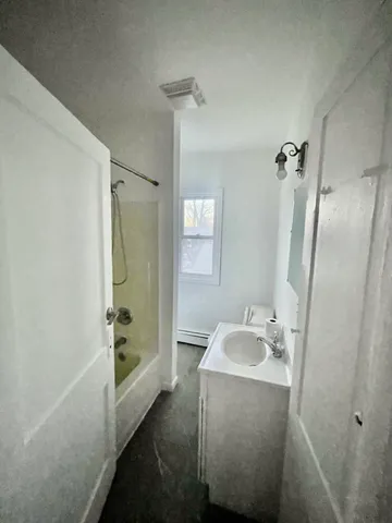 a bathroom with a tub sink and mirror