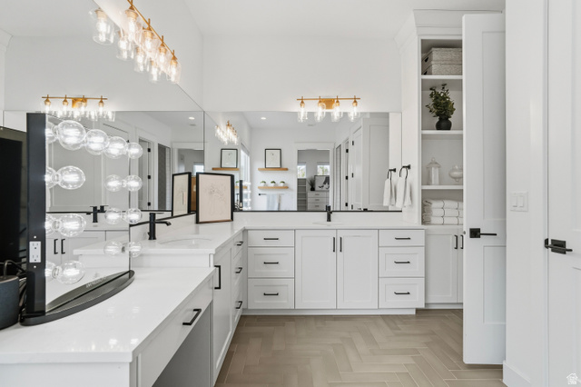 2278 Tawny Ridge Circle St. George, UT 84790 - Photo 26 of 61 Spacious bathroom featuring a double vanity with stone countertops, white shaker cabinetry, and black fixtures.