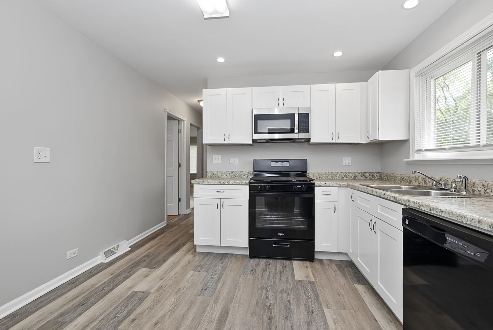 11700 South Harding Avenue Alsip, IL 60803 - Photo 16 of 17 a kitchen with granite countertop a stove top oven a sink dishwasher and a refrigerator with wooden floor