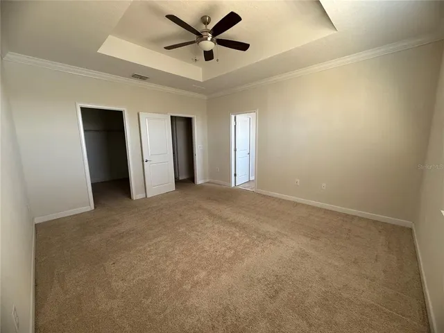 an empty room with a window and a fan
