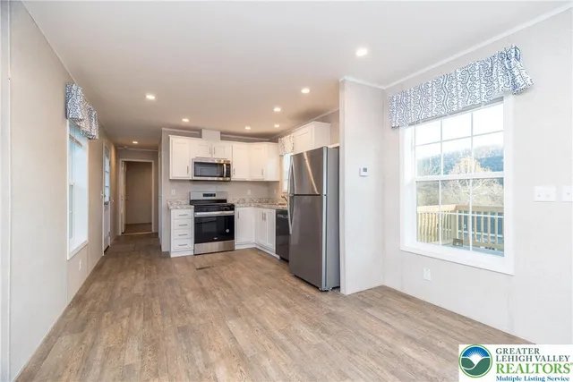 a kitchen with stainless steel appliances a refrigerator sink and microwave