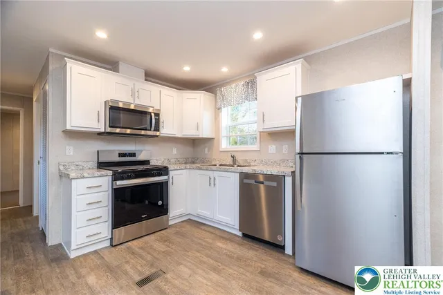 a kitchen with stainless steel appliances granite countertop a refrigerator stove a sink and a microwave