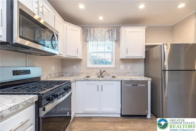 a kitchen with stainless steel appliances granite countertop a stove a refrigerator and a microwave