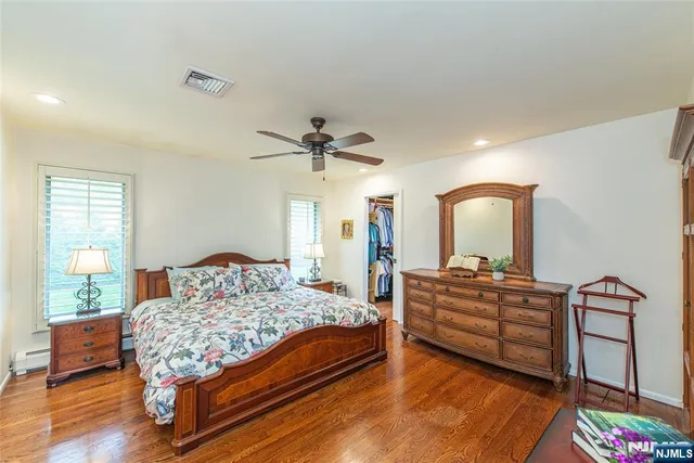a bedroom with a bed and a dresser with mirror