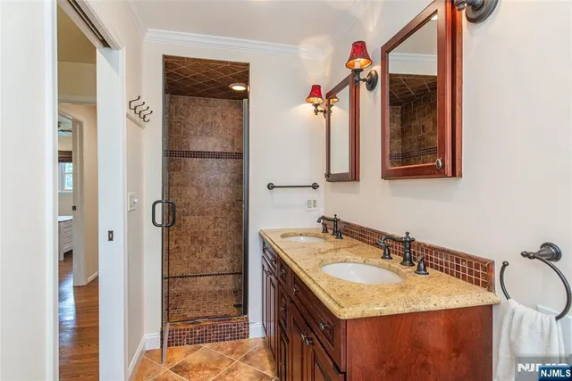 a bathroom with a granite countertop sink a mirror a vanity and shower