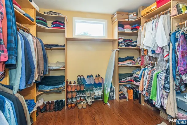 a view of walk in closet with clothes and shoes
