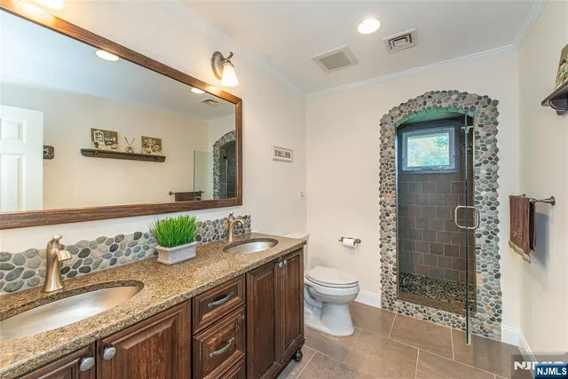 a bathroom with a granite countertop sink a toilet and shower