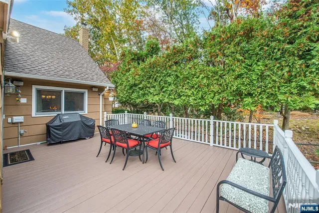 a view of a patio with table and chairs with wooden fence and floor