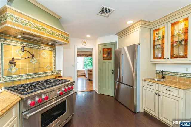 a kitchen with a stove a refrigerator and a window