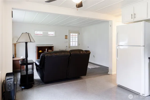 a living room with furniture and a refrigerator