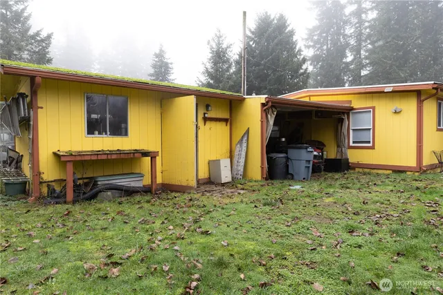 a backyard of a house with barbeque oven table and chairs