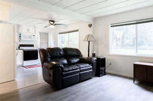 a living room with furniture a flat screen tv and window