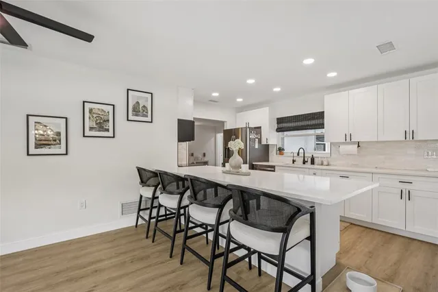 a kitchen with kitchen island a dining table and chairs
