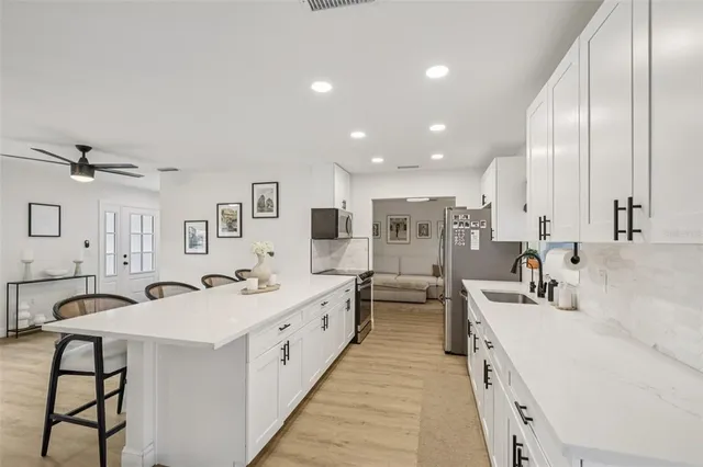a large white kitchen with stainless steel appliances