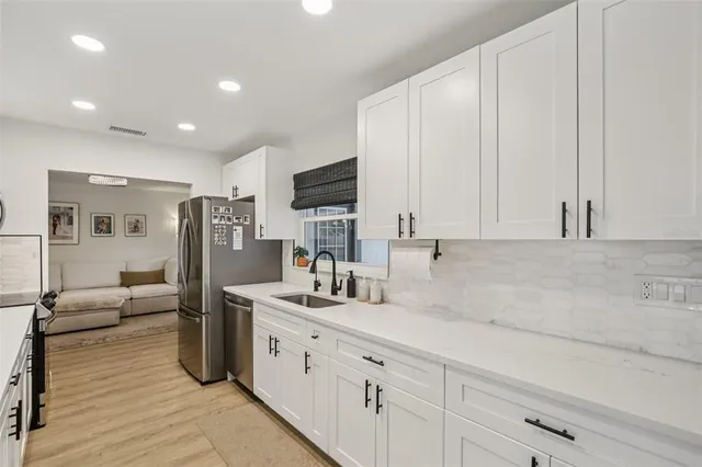 a kitchen with stainless steel appliances a sink stove and refrigerator