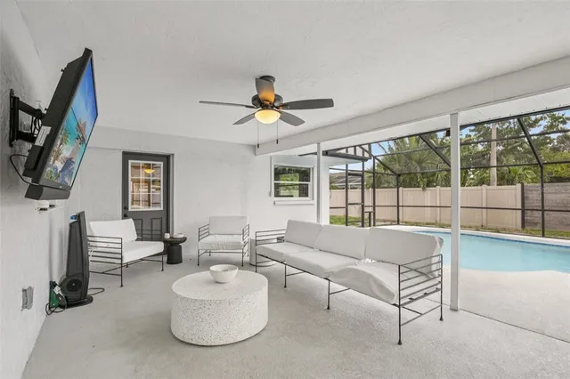 a living room with furniture a flat screen tv and a window