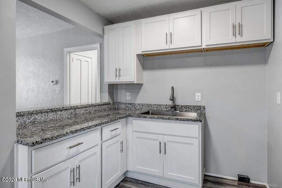 1804 Cleveland Street Jacksonville, FL 32209 - Photo 16 of 25 a kitchen with granite countertop white cabinets and a sink